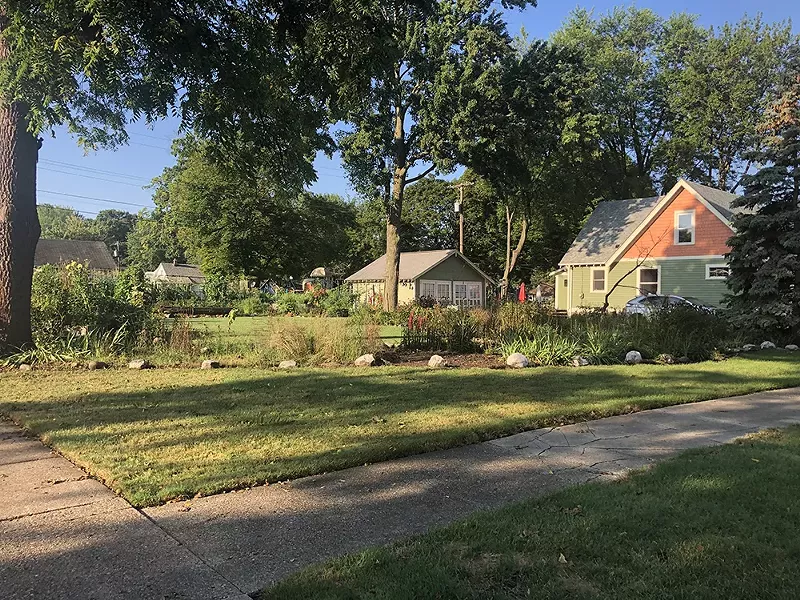 A colorfully painted Hazel park home with a side a side lot garden. - Lee DeVito