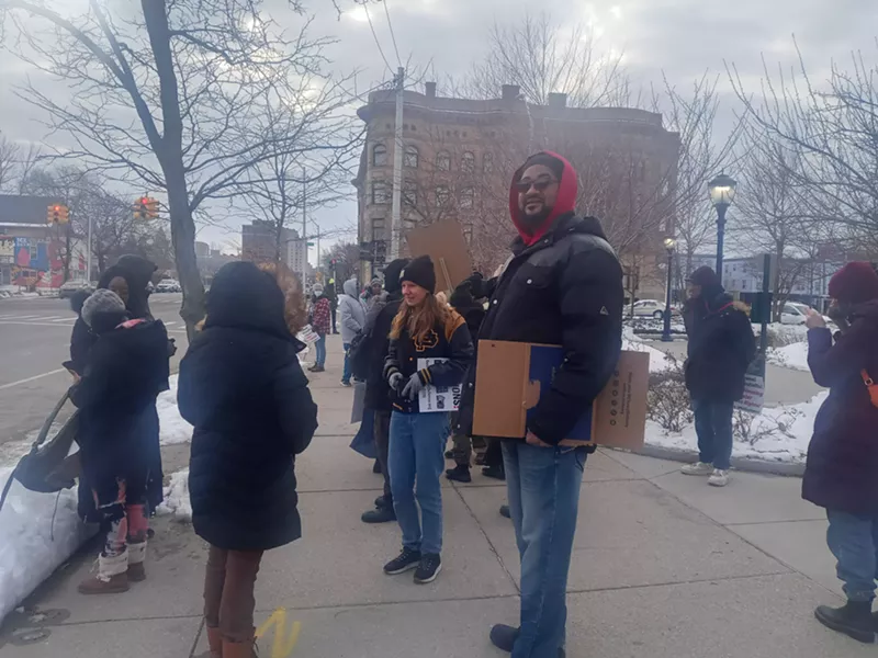 Steven Rimmer (right) waits for housing justice rally to begin. He is a founding member of the Detroit Tenants Association, a coalition formed last year to support tenants facing poor living conditions, advocate for renters' rights, and fight the threat of evictions, among others. - Eleanore Catolico