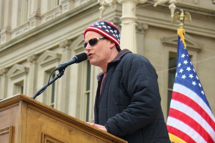 MI Legalize board member Jamie Lowell addresses a crowd at the State Capitol during a 2015 “Stop the Raids” rally in response to police raids of homes and businesses of medical marijuana patients and caregivers. - COURTESY PHOTO