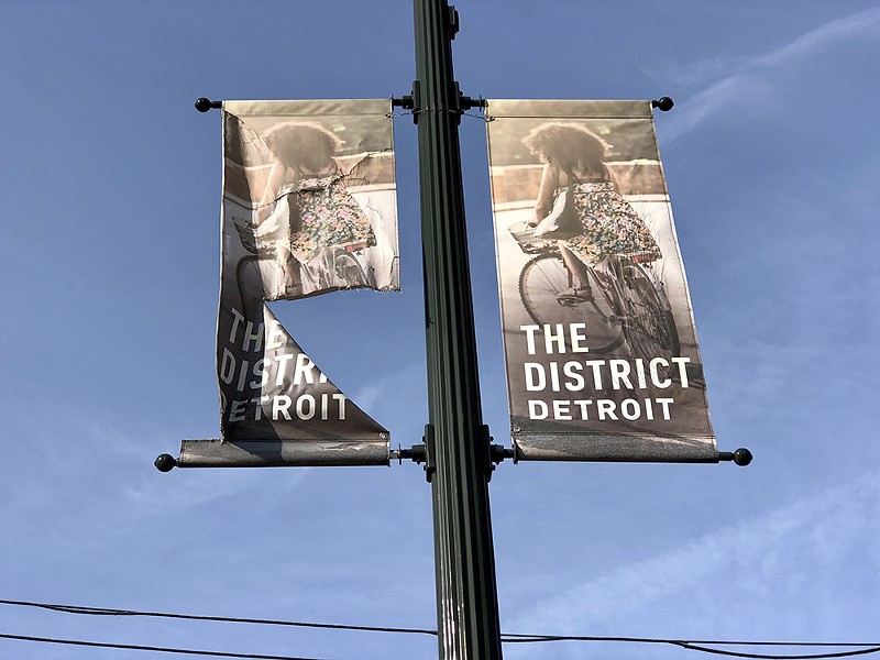 A frayed sign advertising the “District Detroit.” - Steve Neavling