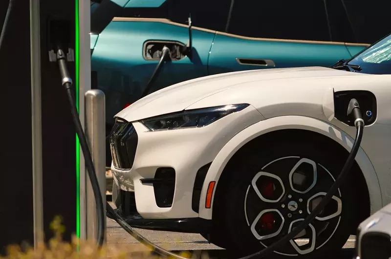 A Ford Mustang Mach-E GT X plugged into a charging station. - Shutterstock