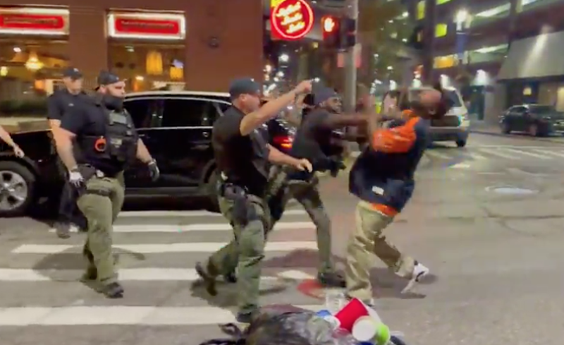 Screenshot of video showing a Detroit cop punching a man in the face in Greektown. - Screenshot