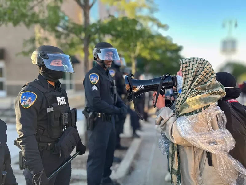 A Muslim activist yells at Wayne State University police, “40,000 dead, and you’re arresting us instead!” - Steve Neavling