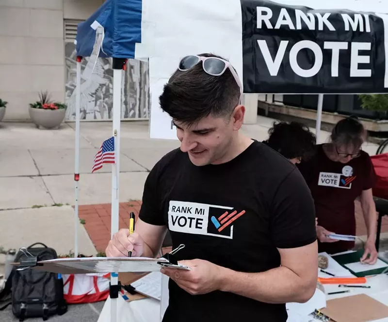 Rank MI Vote executive director Pat Zabawa signs the first signature for the petition to bring ranked choice voting to Michigan at the Ann Arbor Art Fair. - Courtesy photo