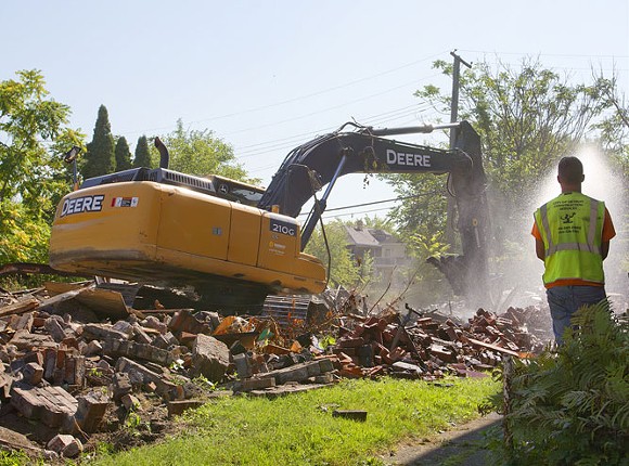 The Detroit Land Bank knocks down a dilapidated house on the city’s west side in September 2015, when Detroit averaged 150 demolitions a week. - STEVE NEAVLING