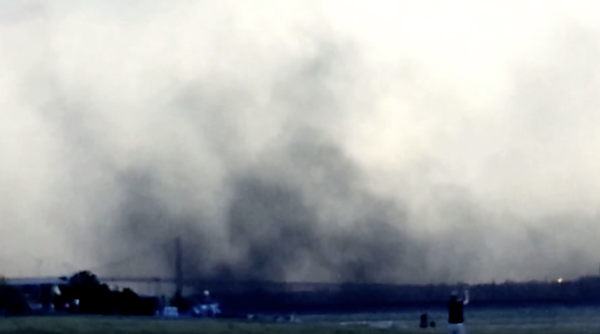 Airborne particles from petcoke piles along the Detroit River swirl above the Ambassador Bridge in 2013. - SCREENGRAB, YOUTUBE