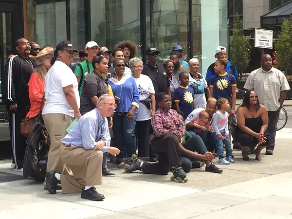 Longtime Detroiters pose for photo in front of building where racially controversial Bedrock ad was taken down. - Violet Ikonomova