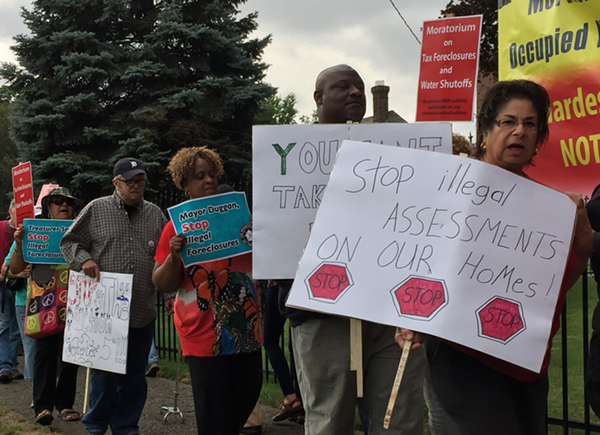 Protesters call on the Wayne County Treasurer to halt the auction until the problem of "illegal tax assessments" can be resolved. - VIOLET IKONOMOVA