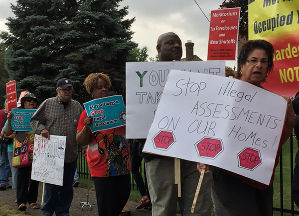 Protesters call on the Wayne County Treasurer to halt the auction until the problem of "illegal tax assessments" can be resolved. - Violet Ikonomova