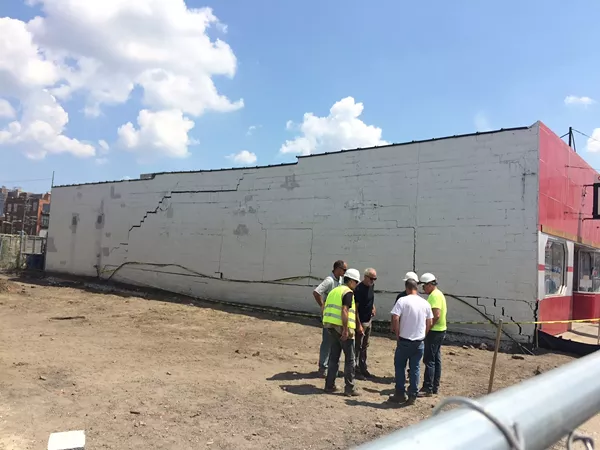 Members of a Monahan Company construction crew gather after they damaged UFO Factory while building an adjacent multi-million dollar residential complex. - Tom Perkins