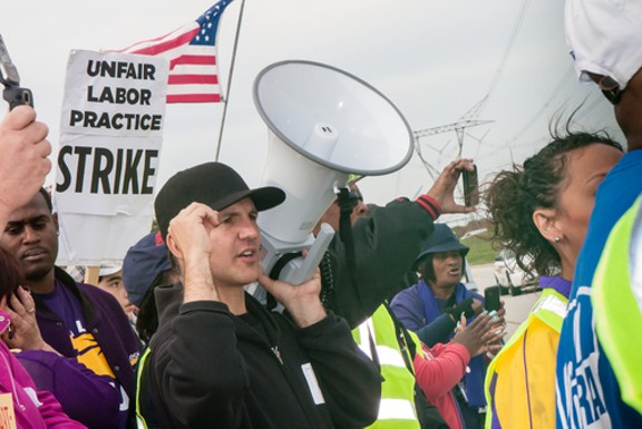 Striking workers and supporters from an Illinois Walmart distribution center march against unfair labor practices, including wage theft, in 2012. - IMAGE COURTESY SHUTTERSTOCK