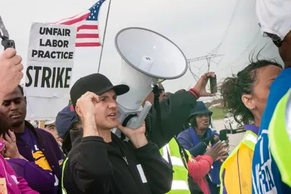 Striking workers and supporters from an Illinois Walmart distribution center march against unfair labor practices, including wage theft, in 2012. - Image courtesy Shutterstock