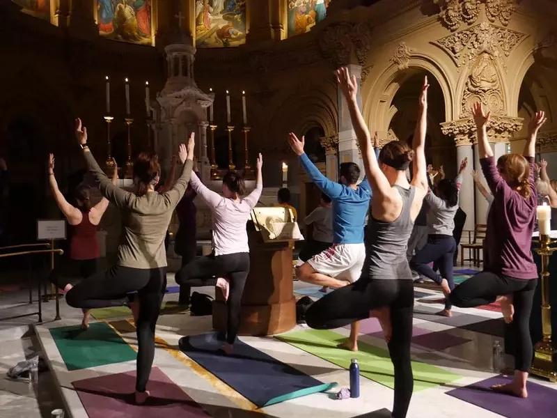 Yogis in tree pose during a Ignatian Yoga flow. - Facebook/Ignatian Yoga