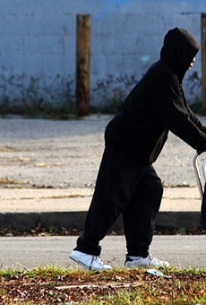 A man pushes a broken walker down Peterboro Street in Detroit.