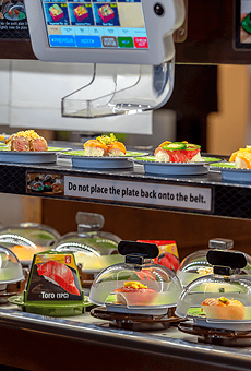 A conveyor belt delivers plates of sushito customers.