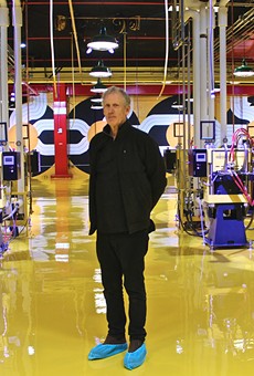 Robert Sestok in Third Man Records' 
new vinyl factory, with his mural behind him.