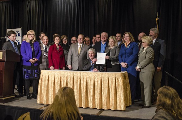 This photo is from an earlier event in Grand Rapids, where Gov. Snyder signed a bill appropriating $28 million in short-term aid for the people of Flint. But, just like this Monday's ovation, Grand Rapids-area power brokers just can't stop standing up for Snyder. - PHOTO COURTESY GOV. SNYDER'S OFFICE