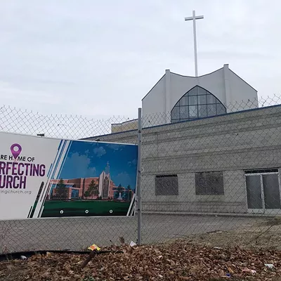 A sign at Detroit’s 18-year Perfecting Church development shows expectations versus reality.