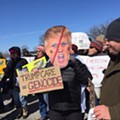 Protesters gather outside President Donald Trump's stop at the American Center for Mobility in Ypsilanti Township.