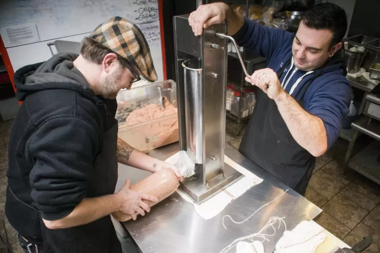 Once Kay's assistant starts cranking, a disc pushes the bologna down the large tube, which forces it through the small tube and into the mylar.