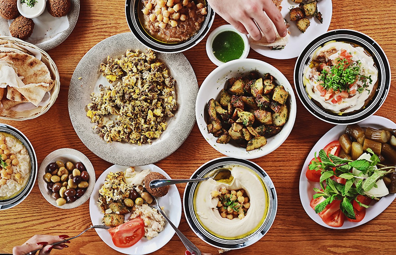 Customers feast on a spread of msabbaha, falafel, olives, eggs with chunk meat, fool, hummus, spicy potato, jalape&ntilde;o sauce, and vegetables Al Tayeb, all dishes that have made Al Tayeb famous and recognized by The New York Times in their list of &#147;50 places in America we&#146;re most excited about right now.&#148;