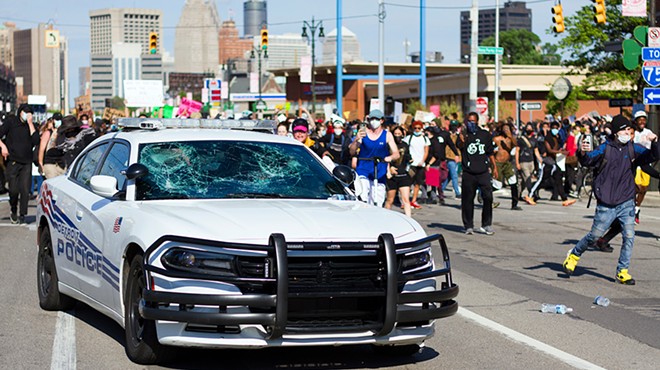 Protesters smashed the windows of a police car in Detroit.